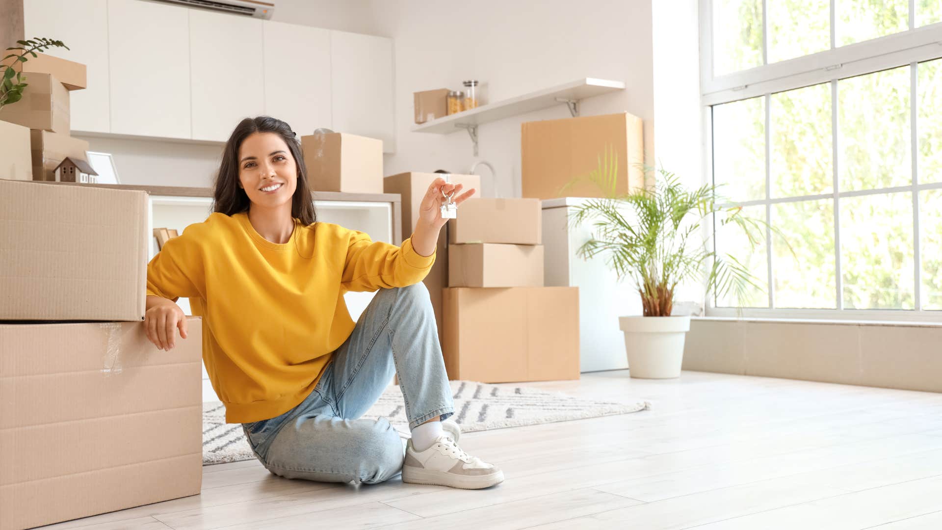smiling woman sitting with moving boxes