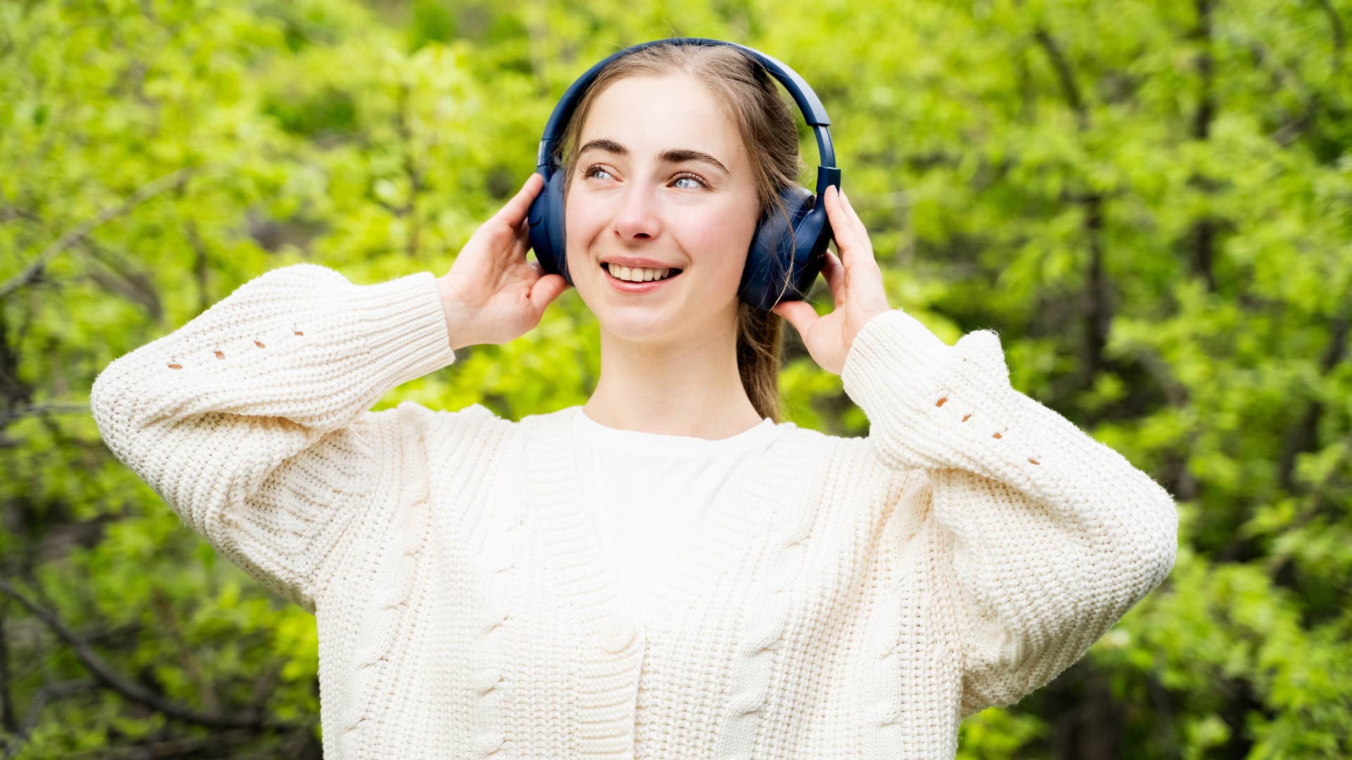 happy smiling woman wearing headphones outdoors