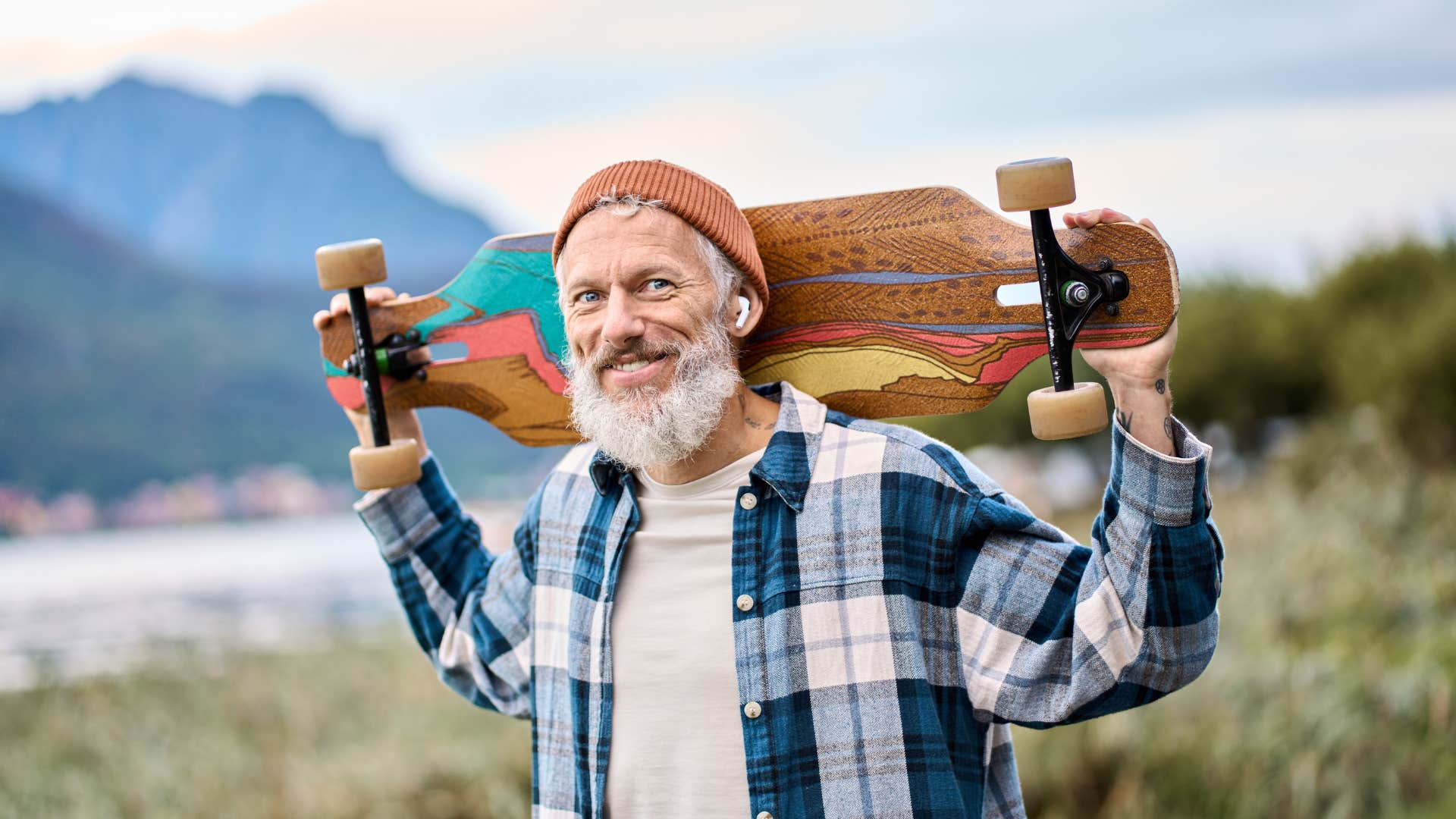 type B man holding longboard seeking life balance