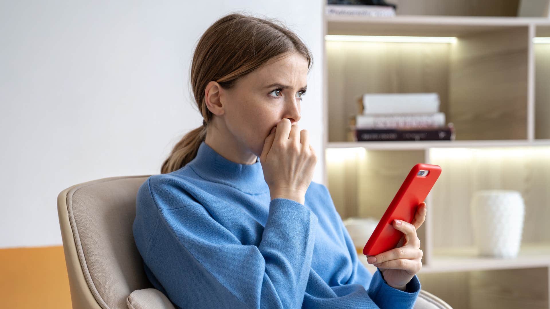 woman in blue shirt looking nervous as she thinks about social media safety concerns