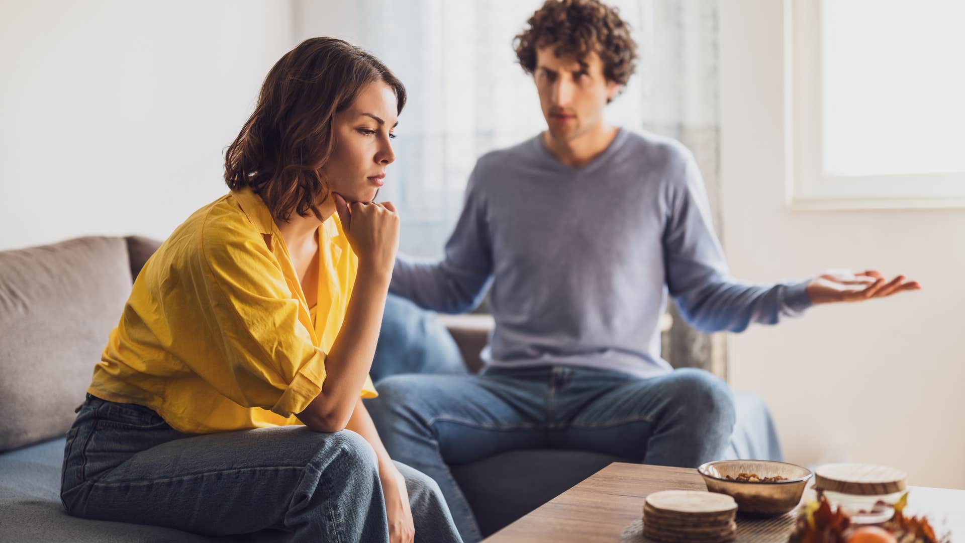 couple arguing while sitting on sofa
