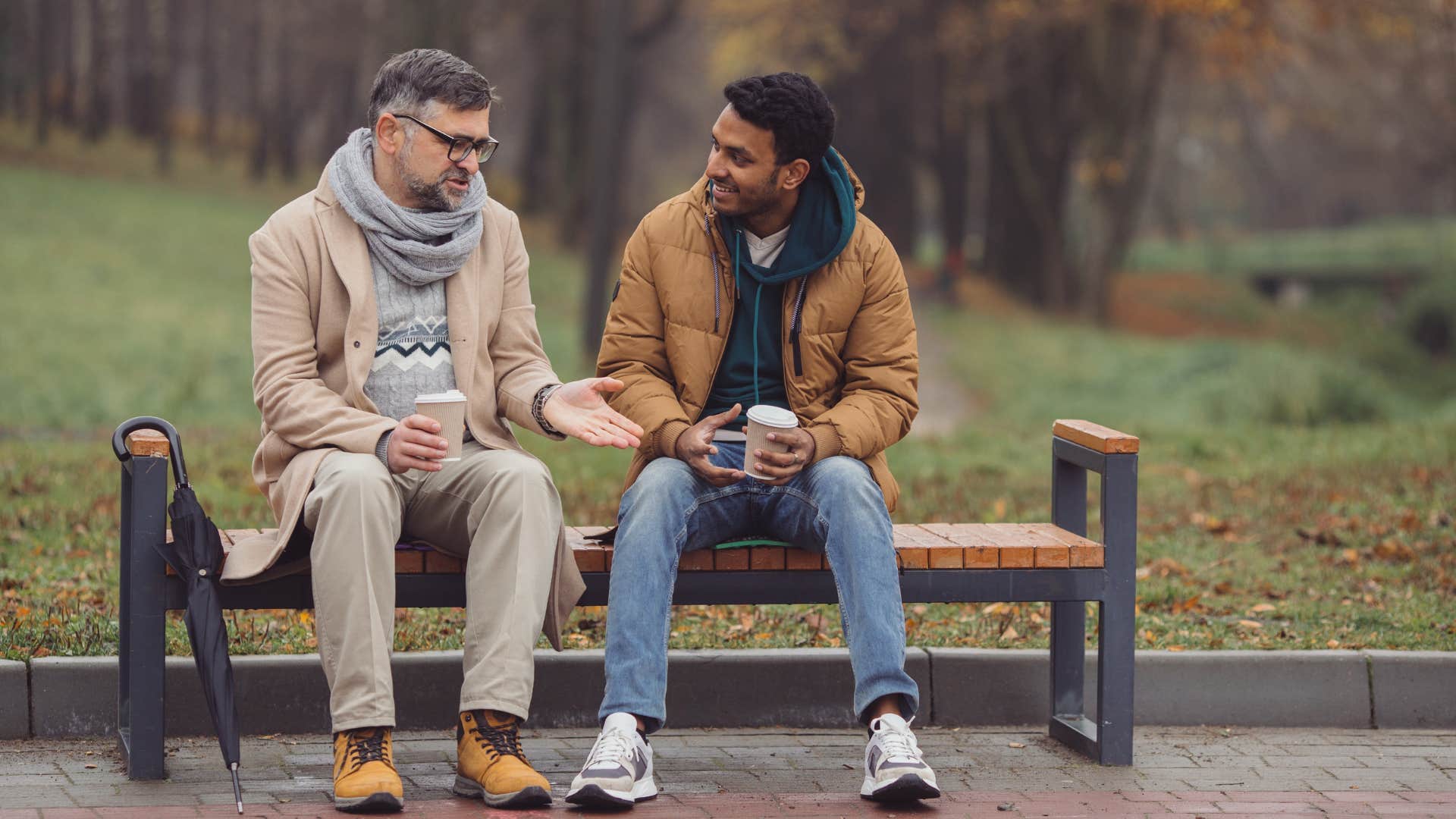 two men sitting together checking on each other