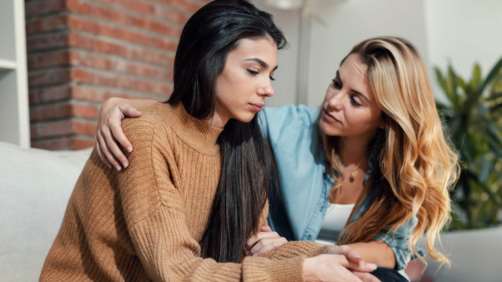 woman comforting friend feeling remorse for hurting her feelings