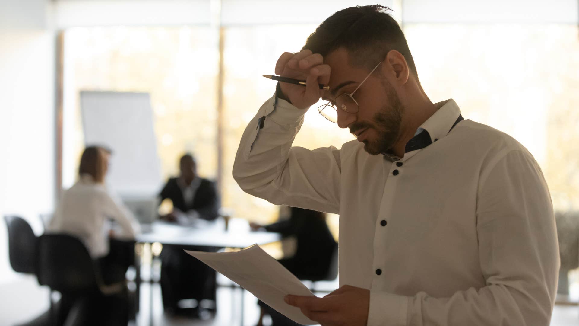 stressed man downplaying his accomplishments at work