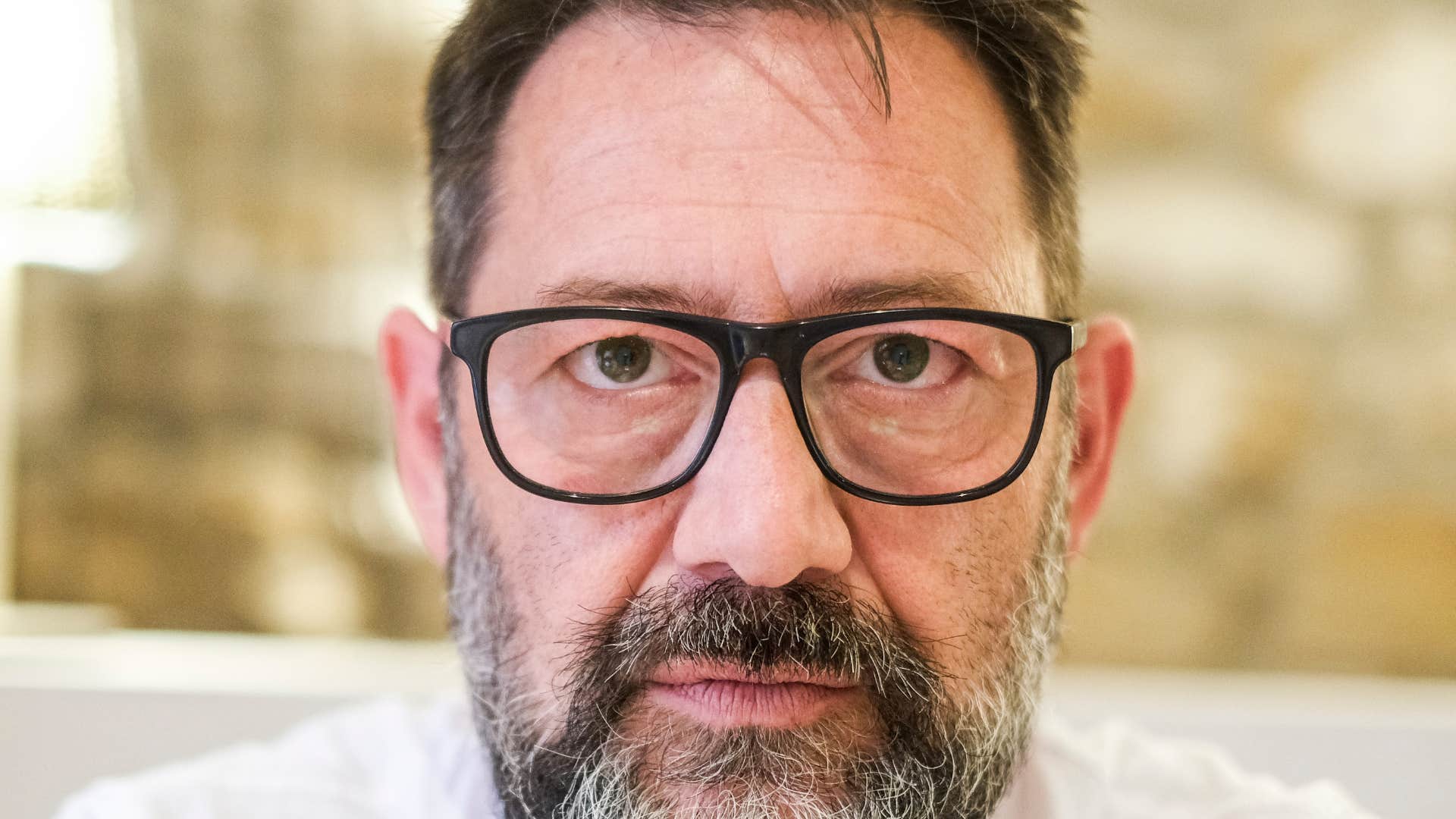 older man suppressing his emotions looking serious