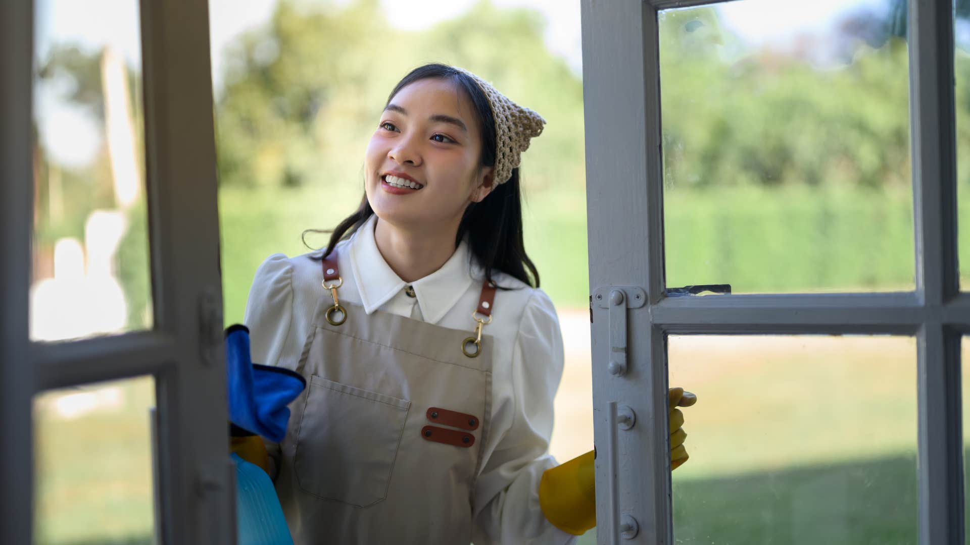 woman cleaning and tiding her windows