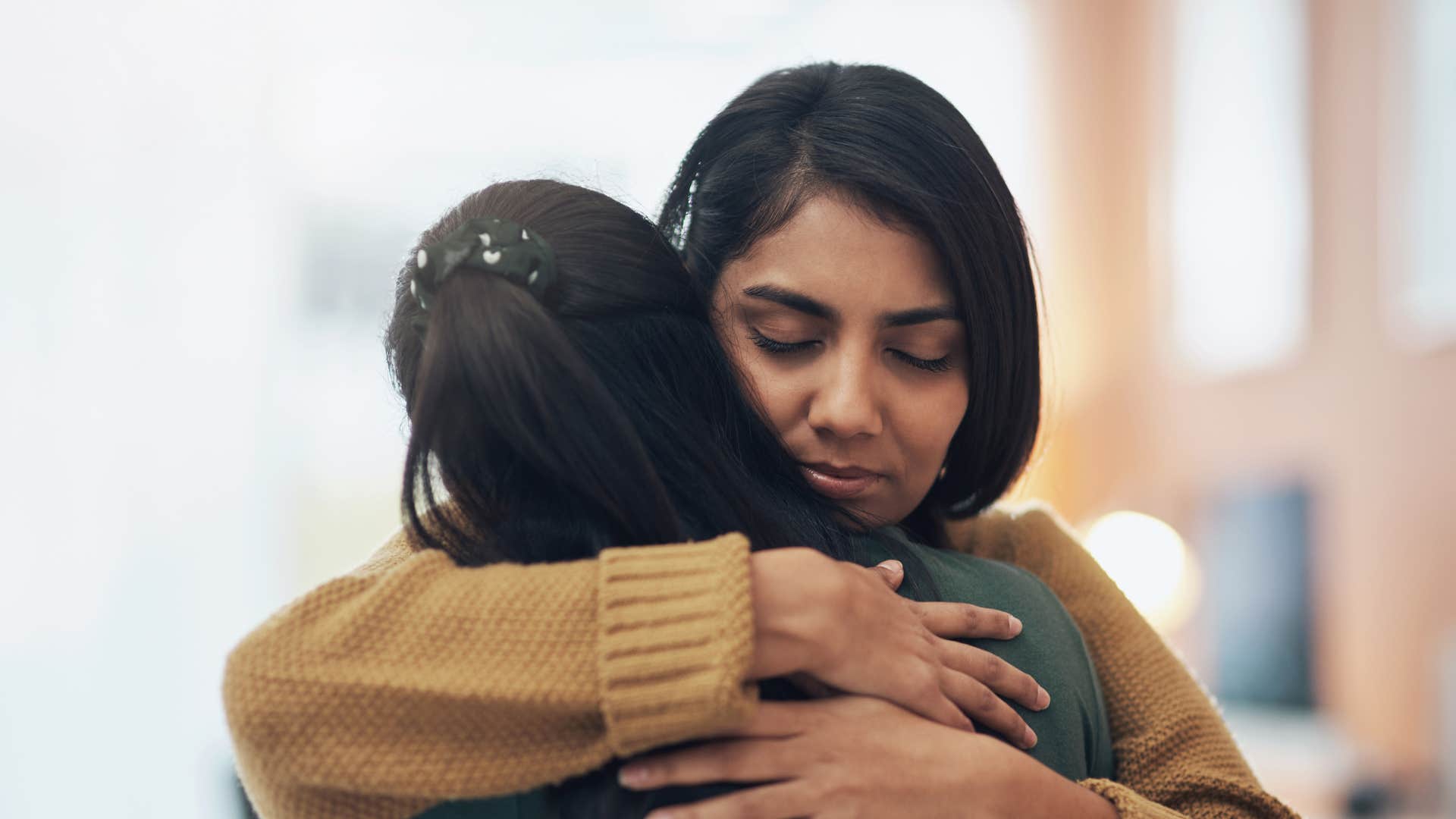 woman hugging friend handling conflict calmly