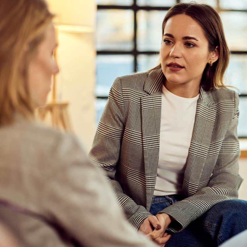 Woman being corrected by a peer at work.