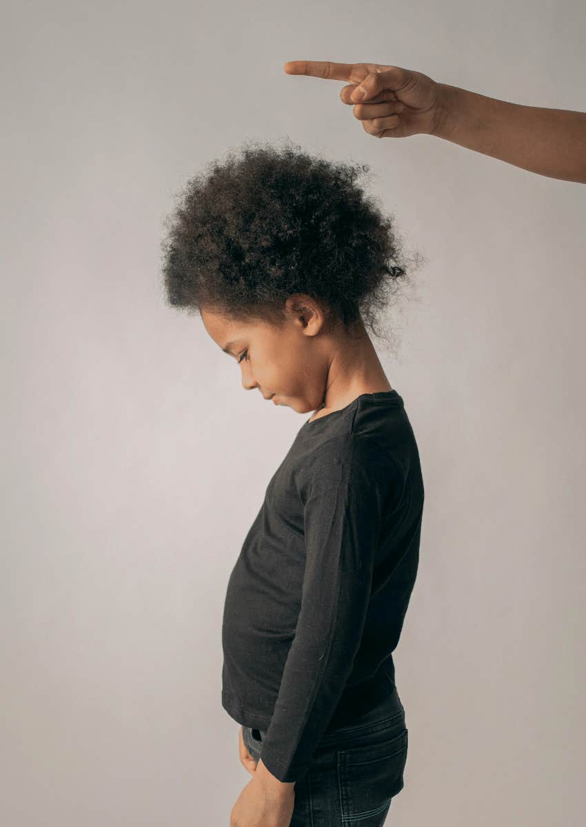 unhappy child being turned away by an adult