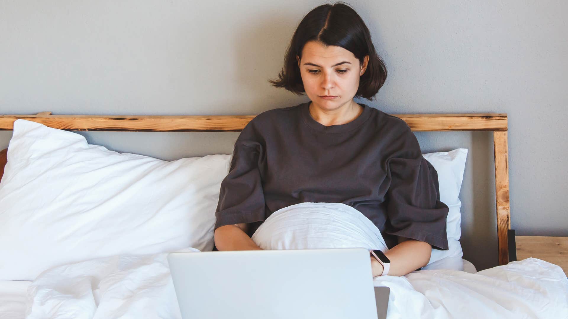woman operating on autopilot working in bed