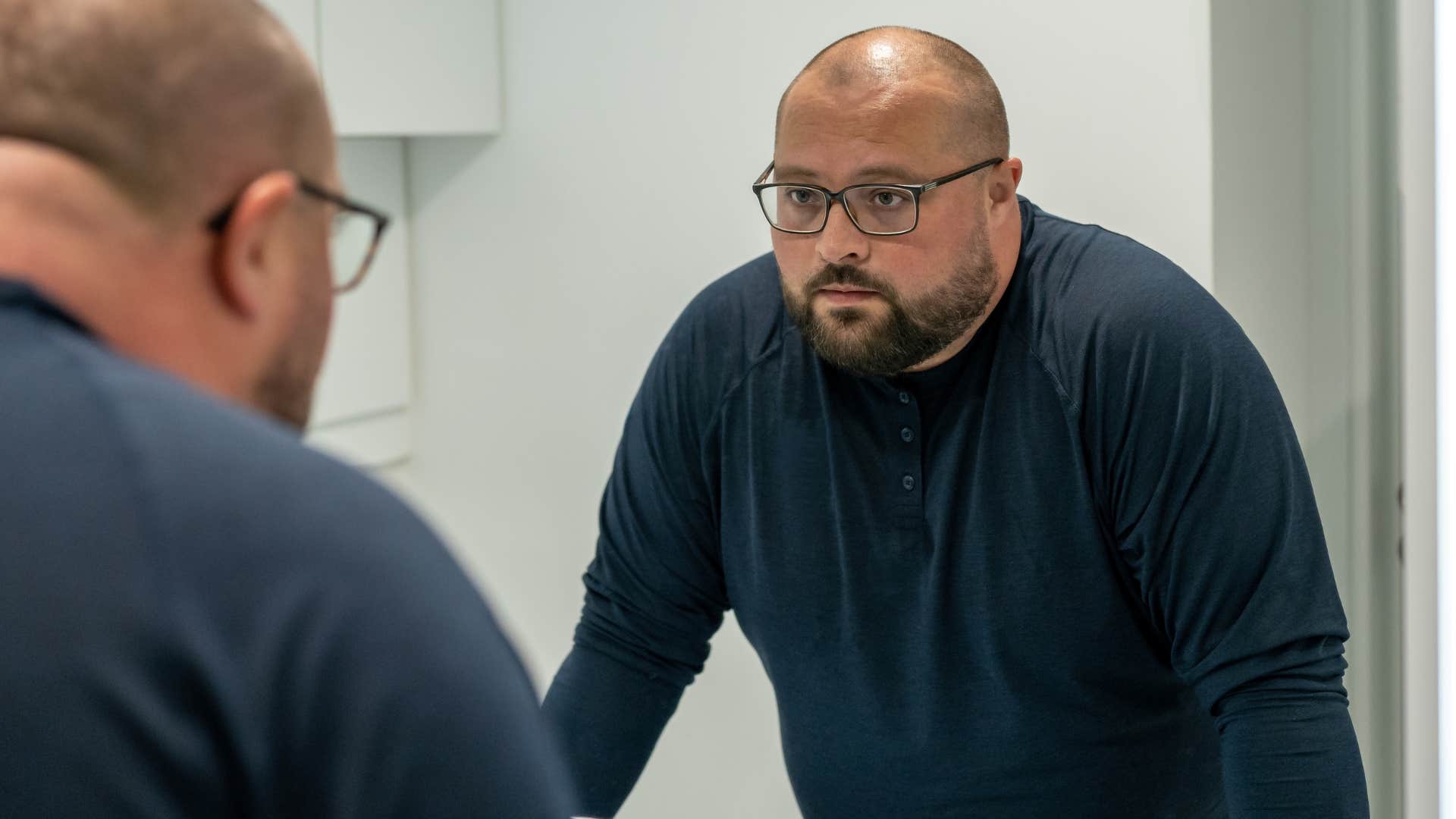 unhappy man rushing through self-care routine