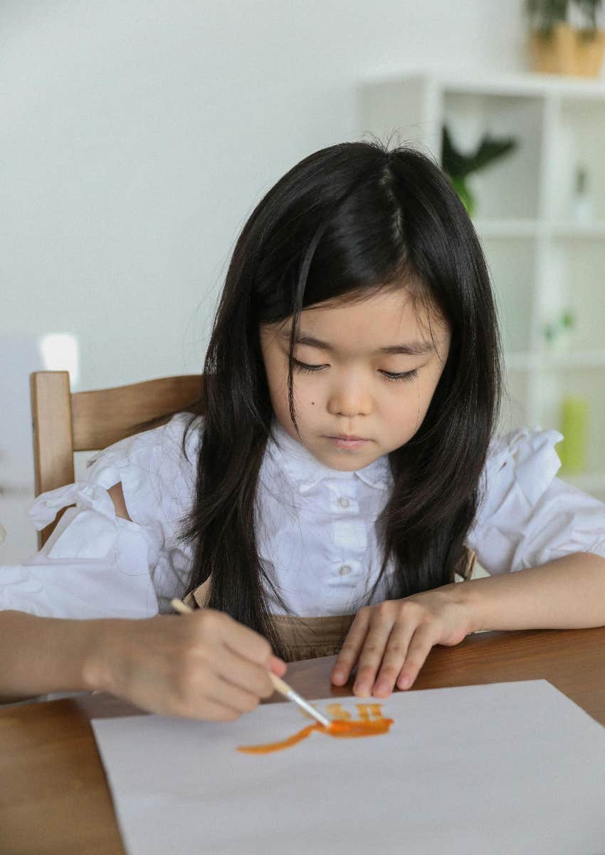 little girl drawing a picture for a letter to a solider