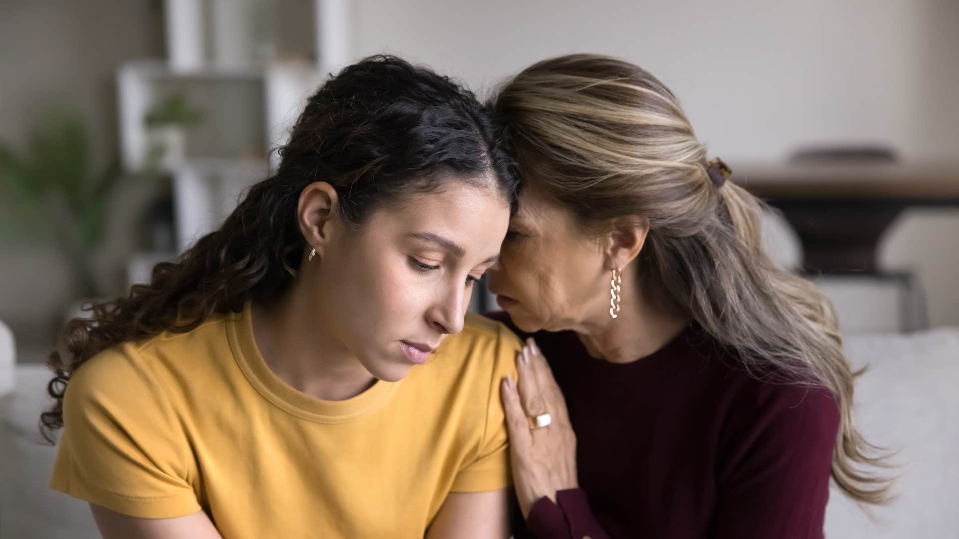 mom in red over validating child's feelings while under teaching coping skills as she comforts woman in yellow