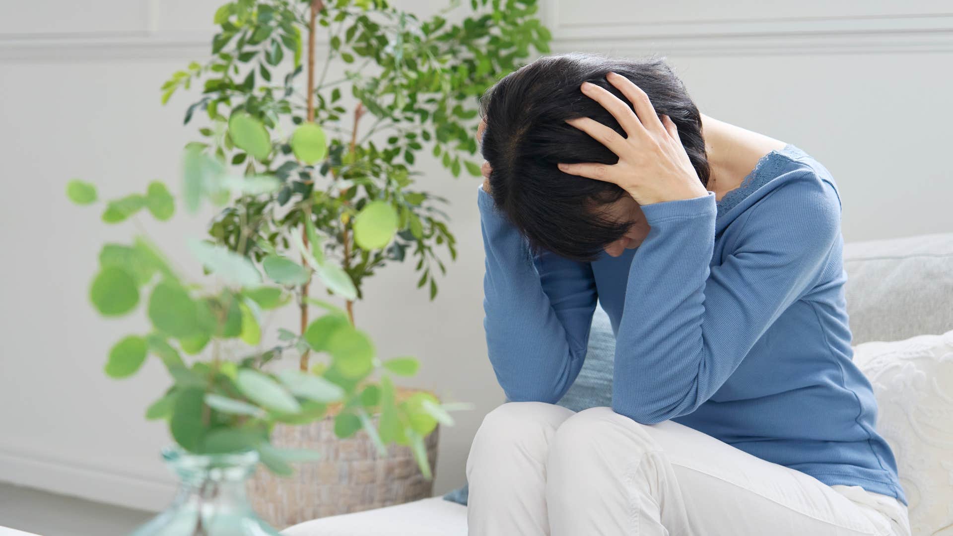 parent in blue looking stressed as she avoids assertiveness out of fear of being too harsh