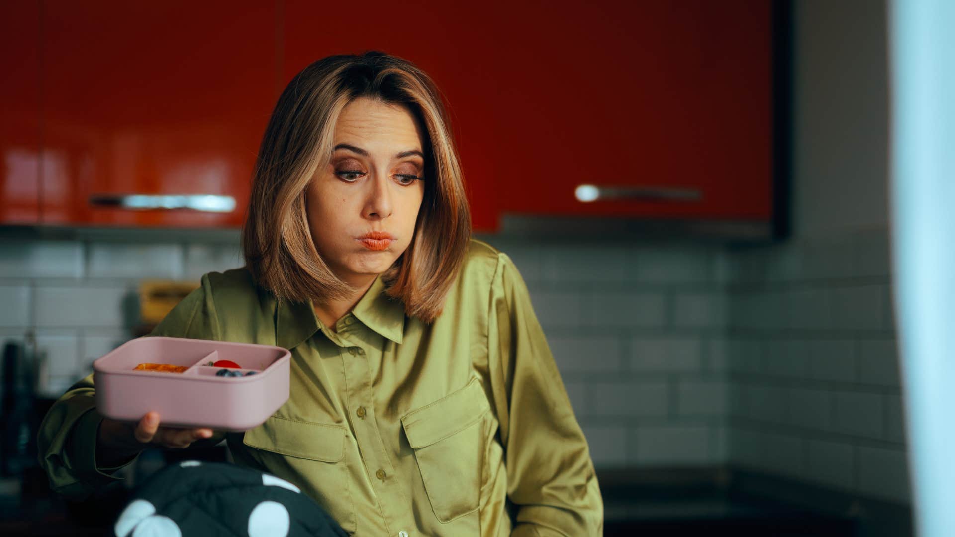 mom in green looking overwhelmed as she prioritizes child centered homes
