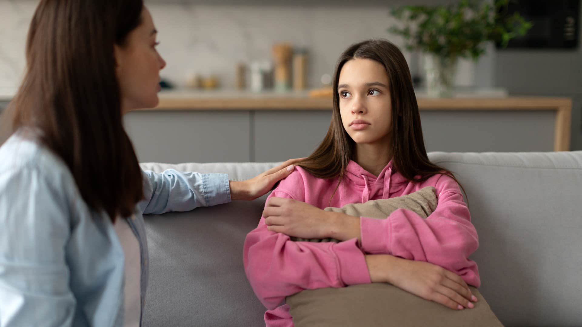 child in pink receiving comfort as mom prioritizes emotions over basic instructions
