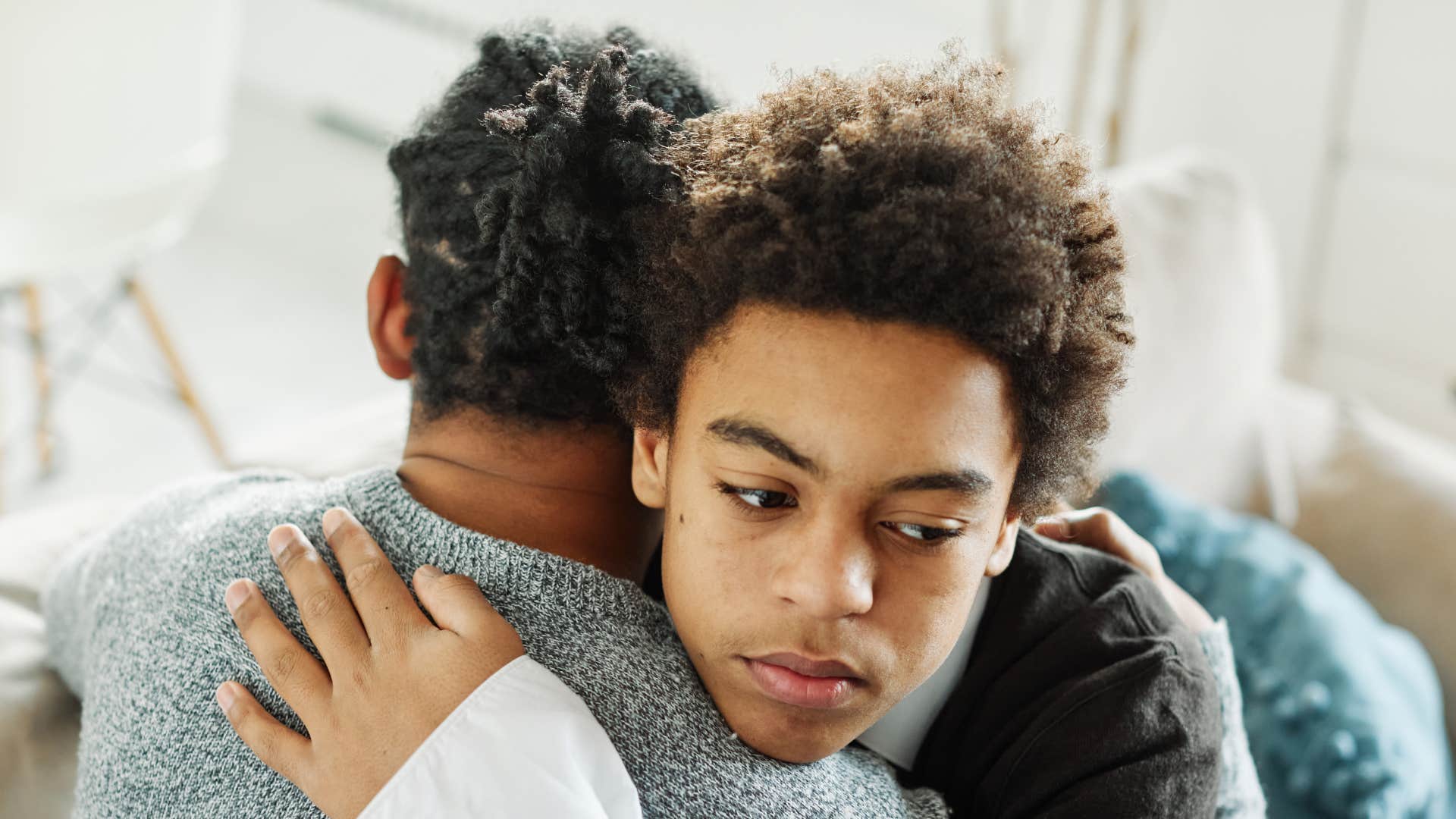 dad hugging son as he does his best to shield kids from discomfort