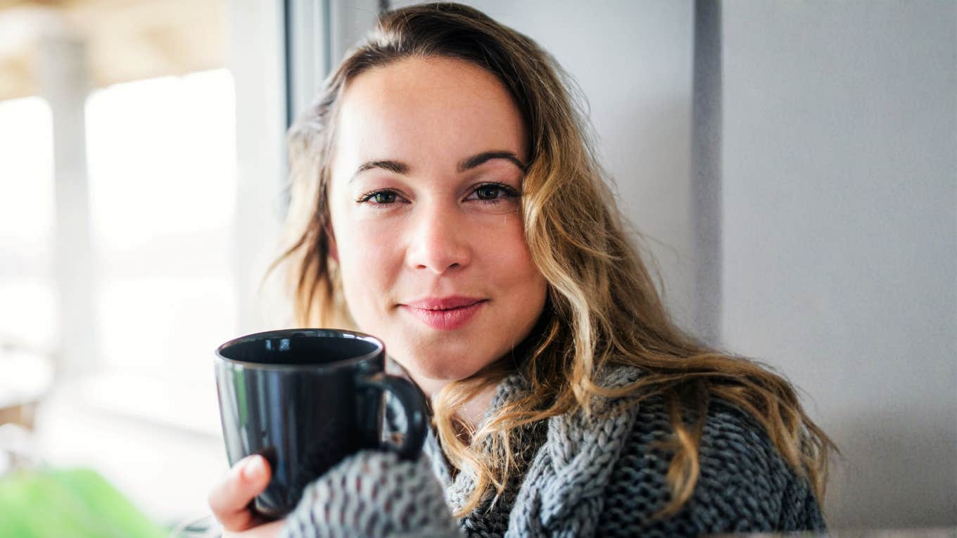woman taking a calm grounding moment with a warm drink, illustrating simple ways to stay in a good mental place when your partner is being a major bummer.