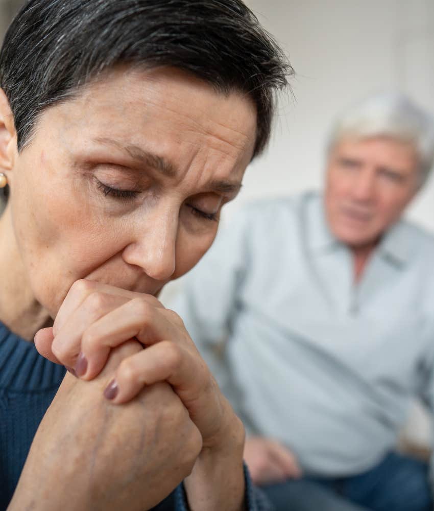 Upset spouse holds hands instead of reacting showing how to stay in good place mentally 