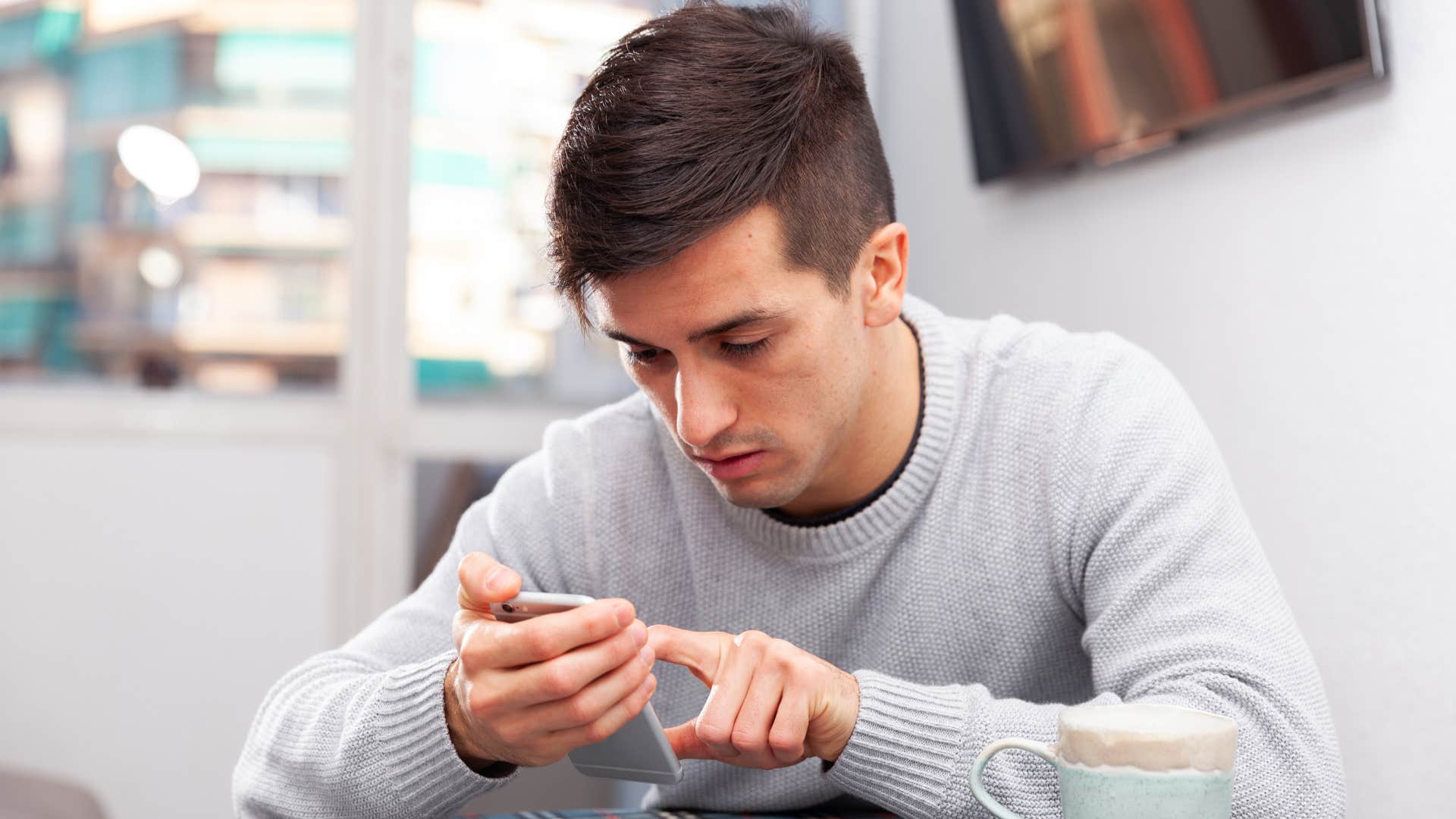 man keeping goals to himself on his phone
