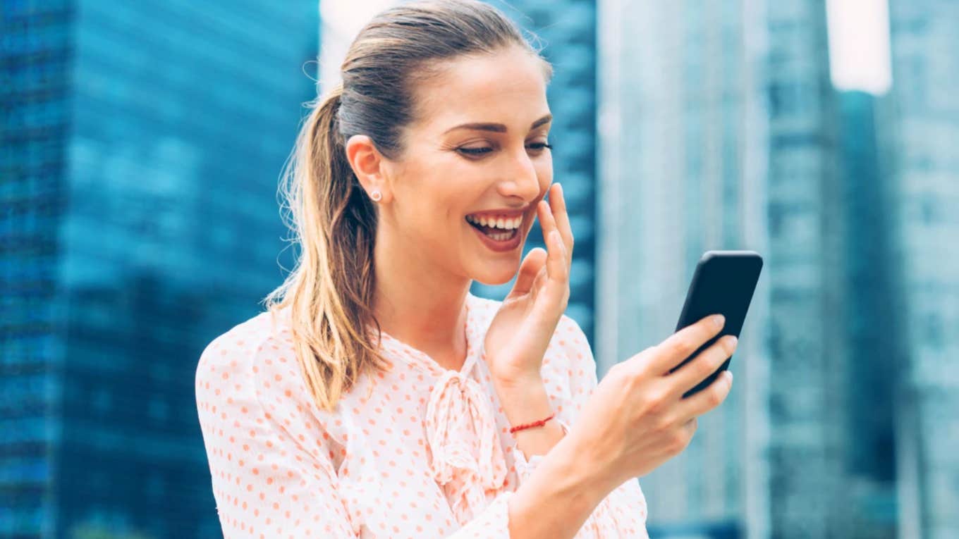 Wife laughing at a text from her husband that she loves 