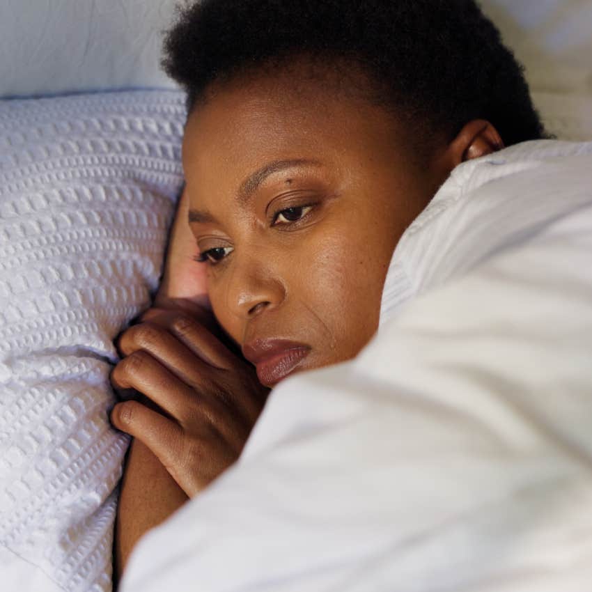 woman dealing with her suppressed emotions laying in bed