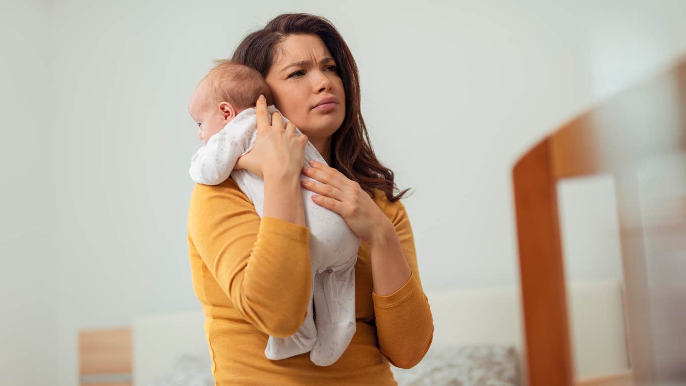 mom stressed about paying rent holding newborn baby