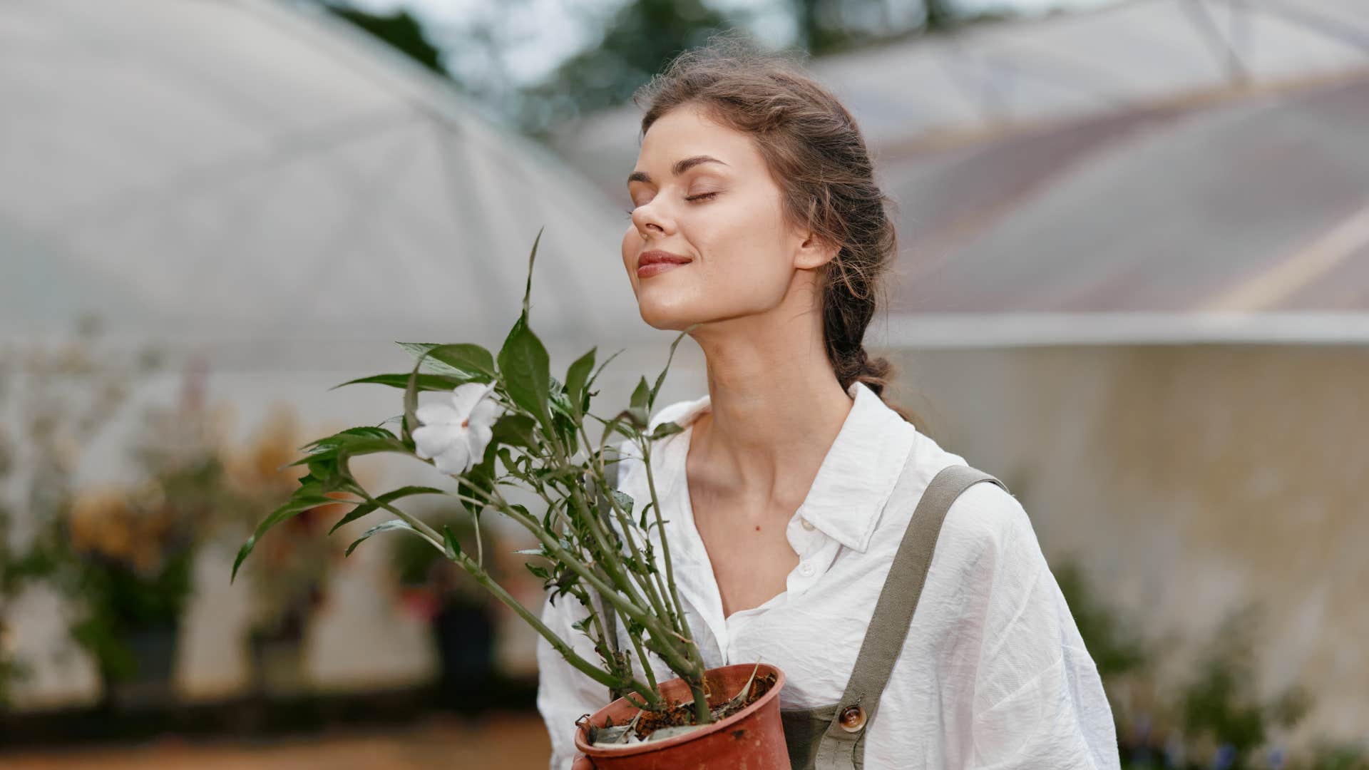 woman smiling holding plants