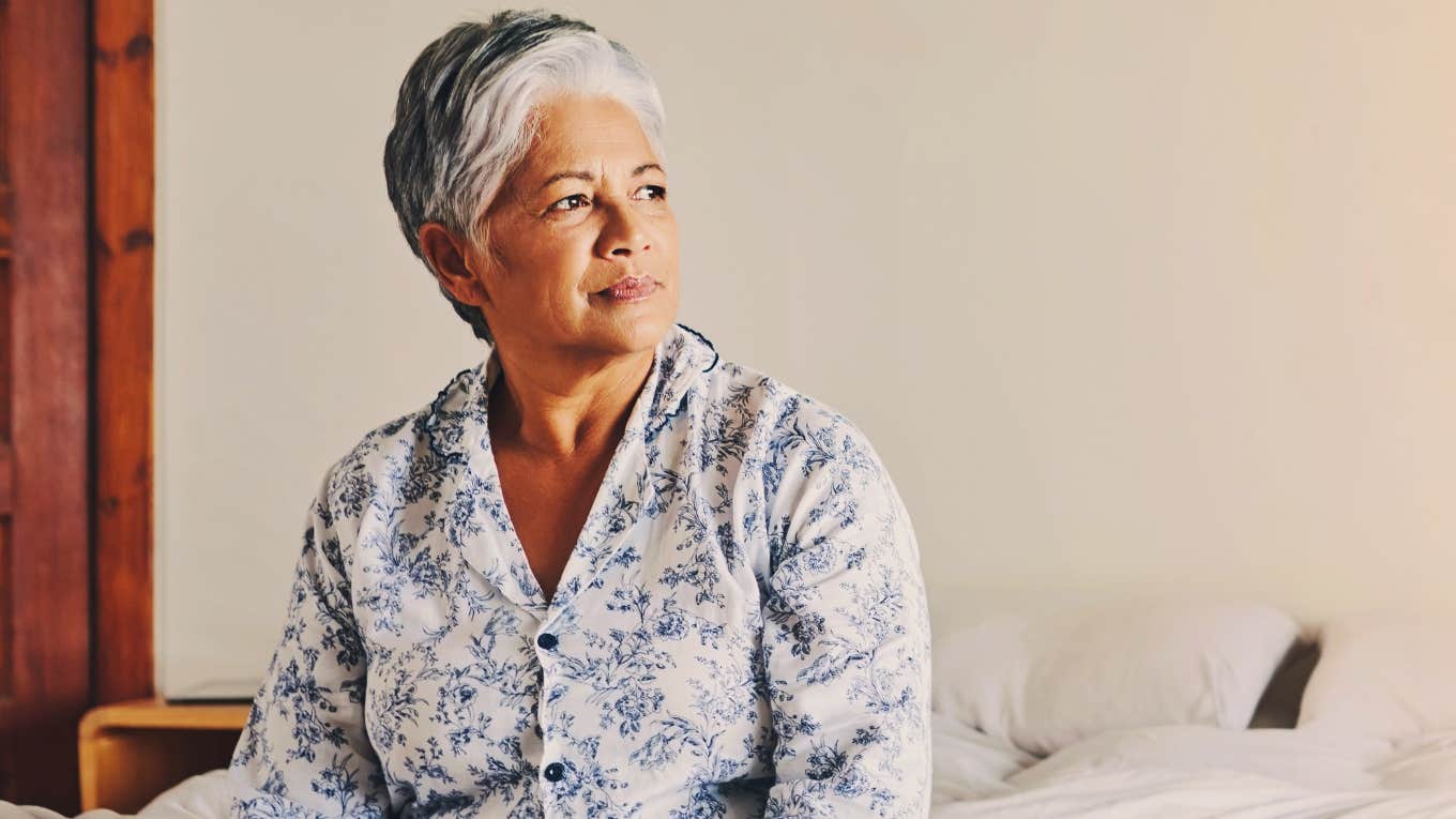 older woman waking up before 6am sitting in bed