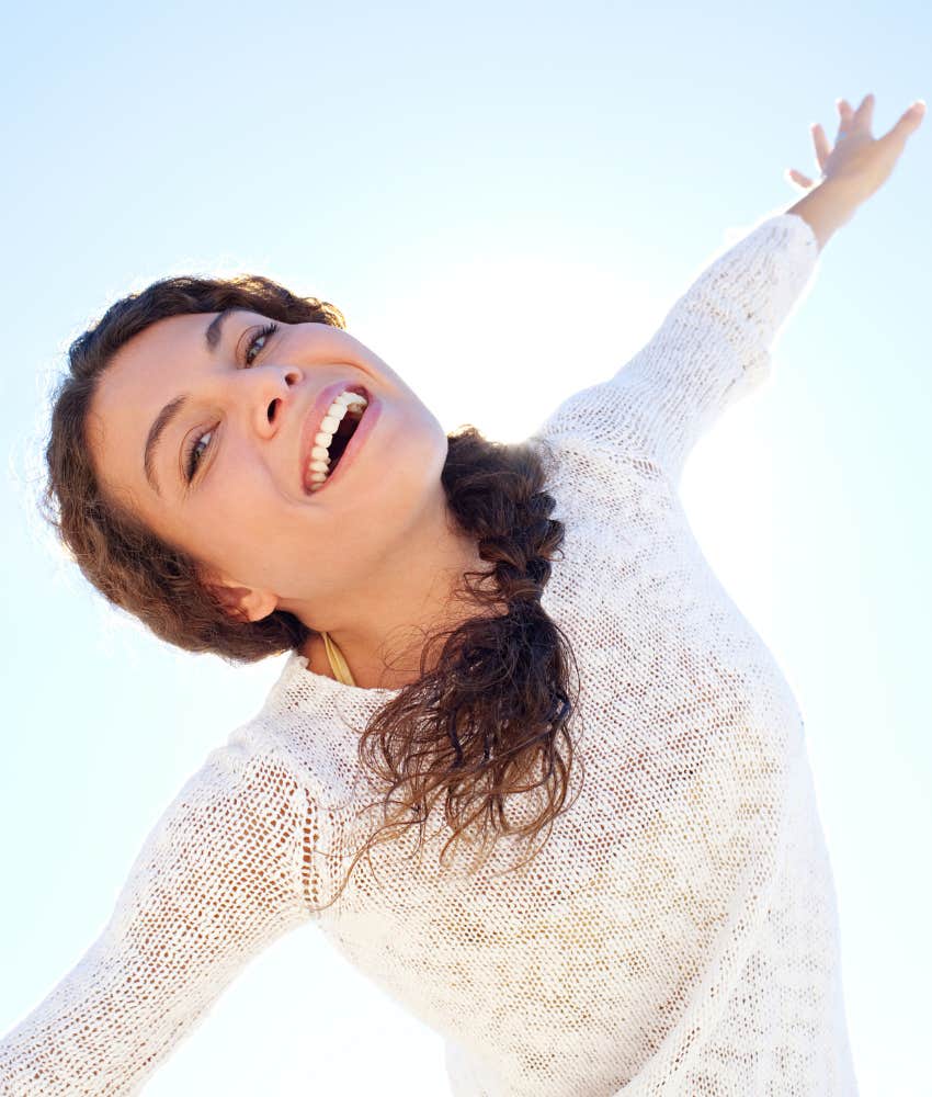 Happy woman spreads arms showing how to not burn out
