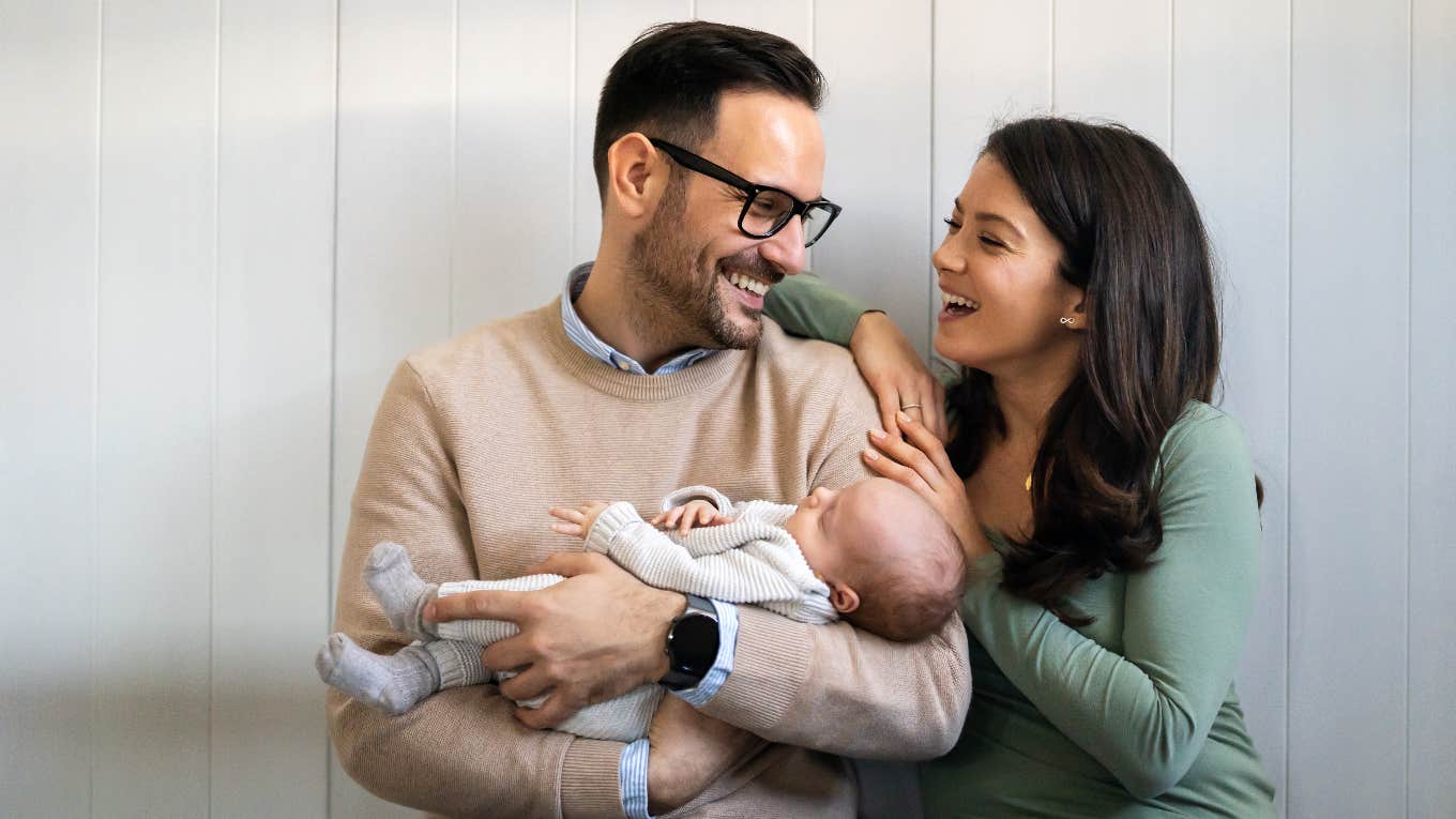 happy couple holding baby