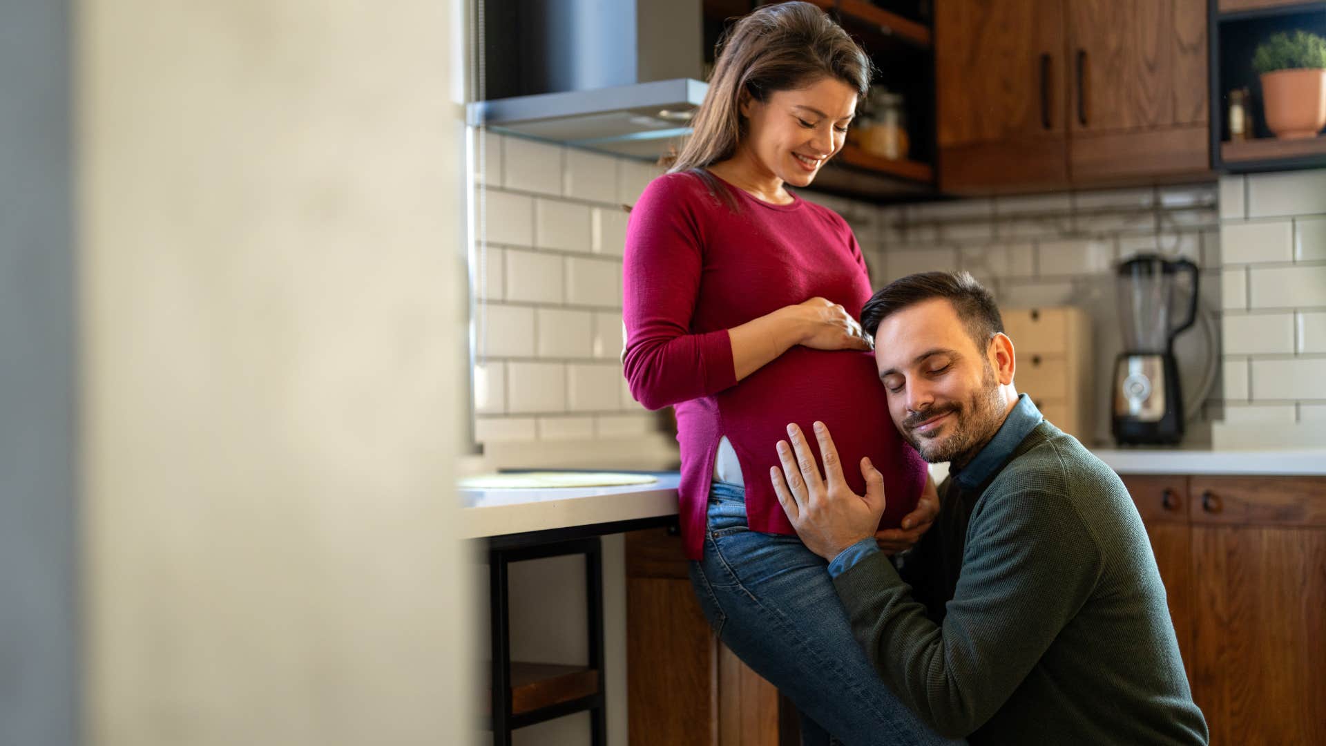 man cuddling with pregnant woman's belly