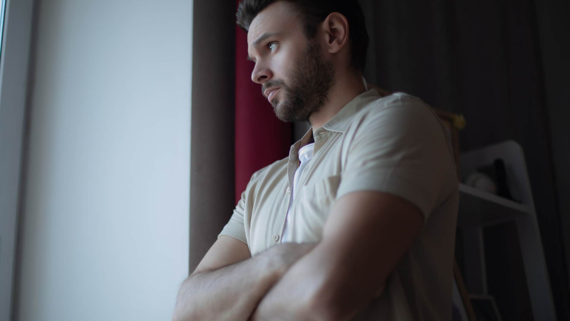 man looking out the window struggling to set healthy boundaries