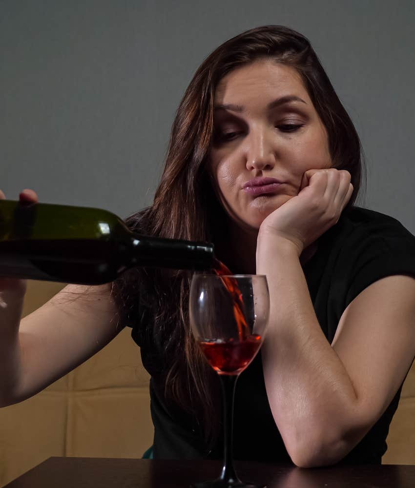Disgruntled person fills their wine glass showing partying too much is only friend