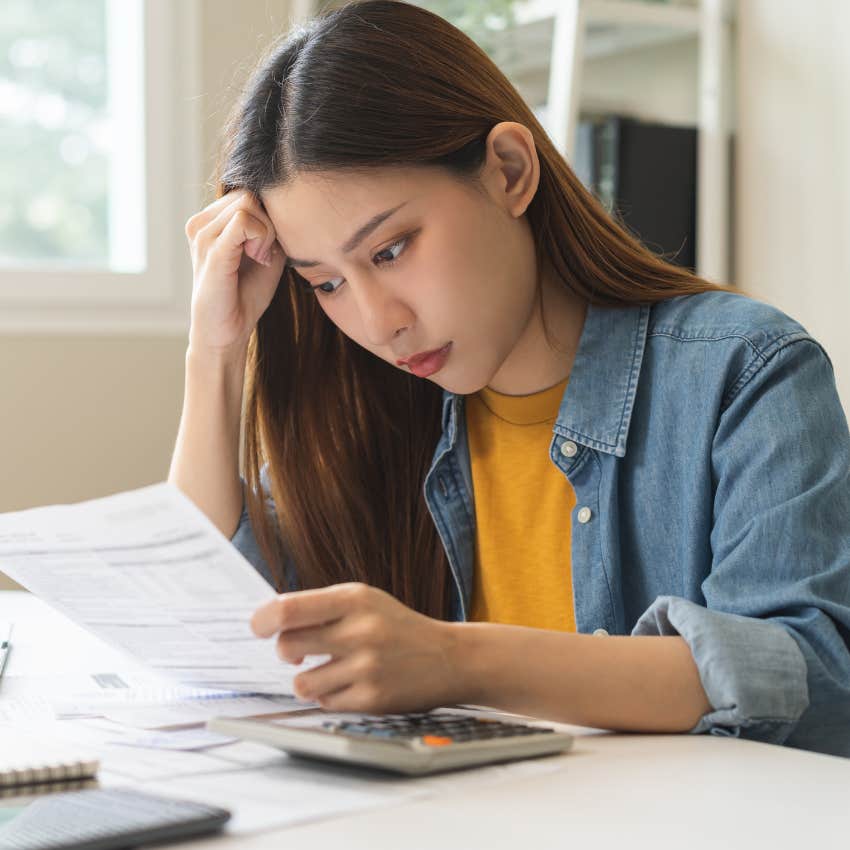 woman looking at bill feeling guilty about spending on herself