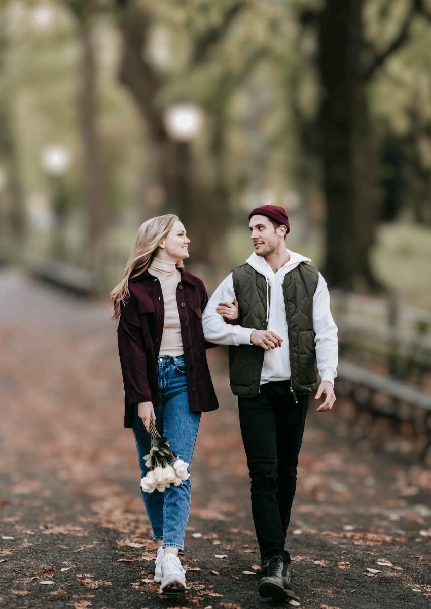 young couple walking through park together