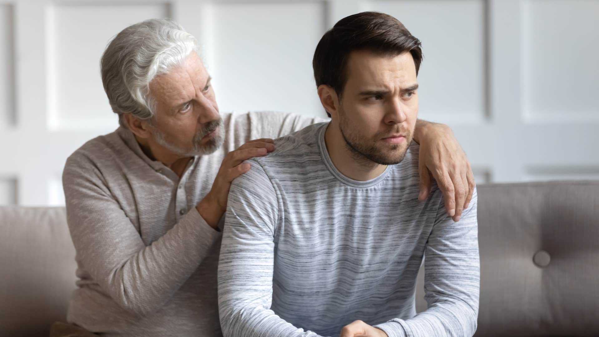 older father touching son's shoulders saying you'll always be our baby