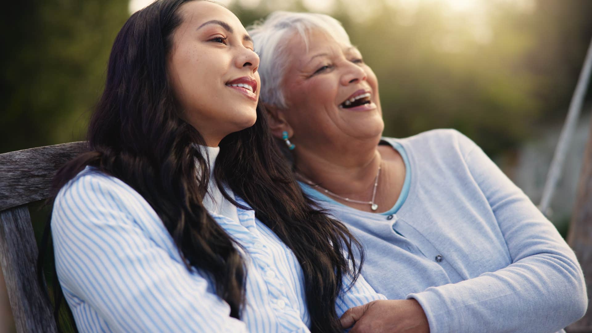 mom holding adult daughter's arms telling her she's growing up so fast