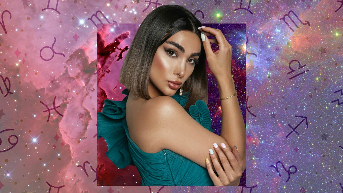 Woman posing against cosmic background with zodiac symbols, representing four zodiac signs rewarded by the universe on December 4, 2025