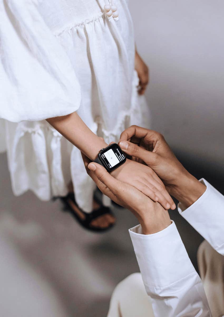 adult placing a smartwatch on a kid's wrist