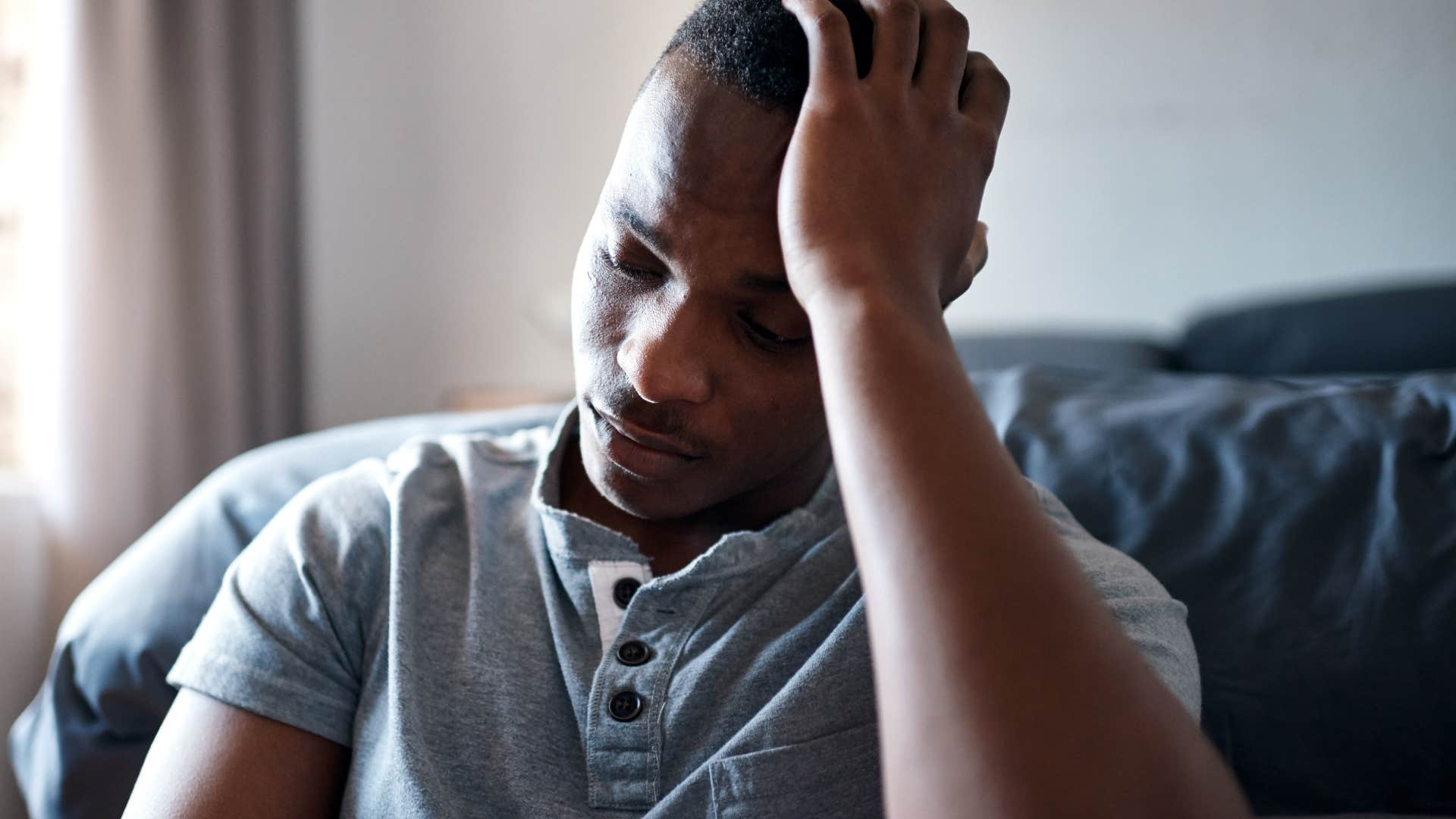 upset man holding head feeling stressed after talking to his parents on the phone