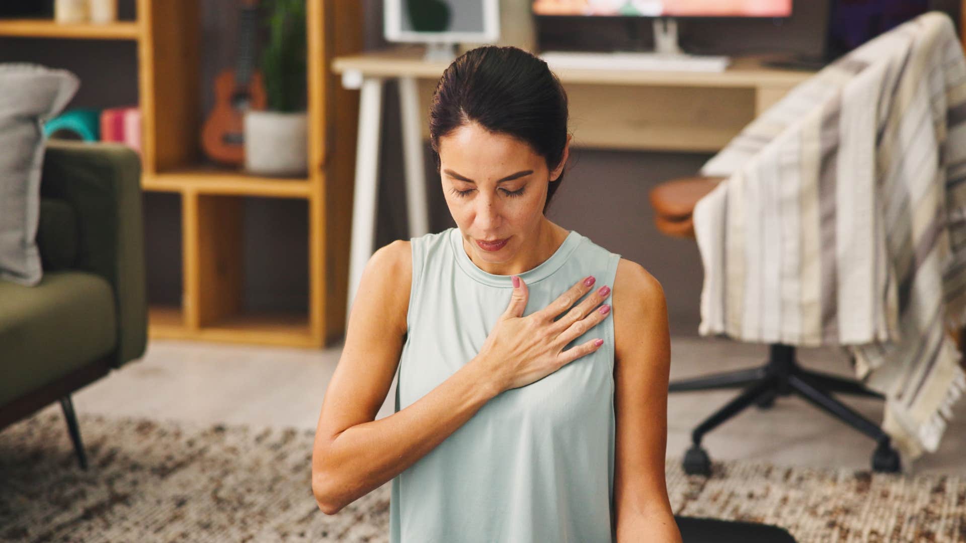 Quiet person places hand on heart to mourn tough year and heal