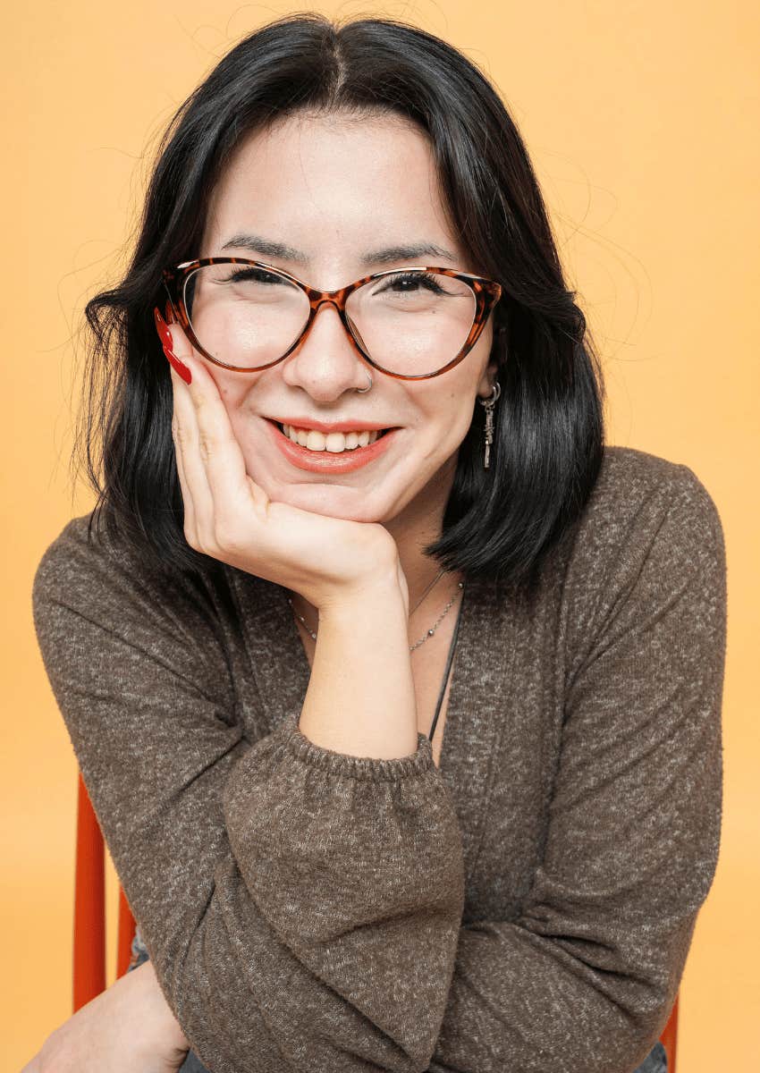 asian woman in glasses smiling wide with happiness