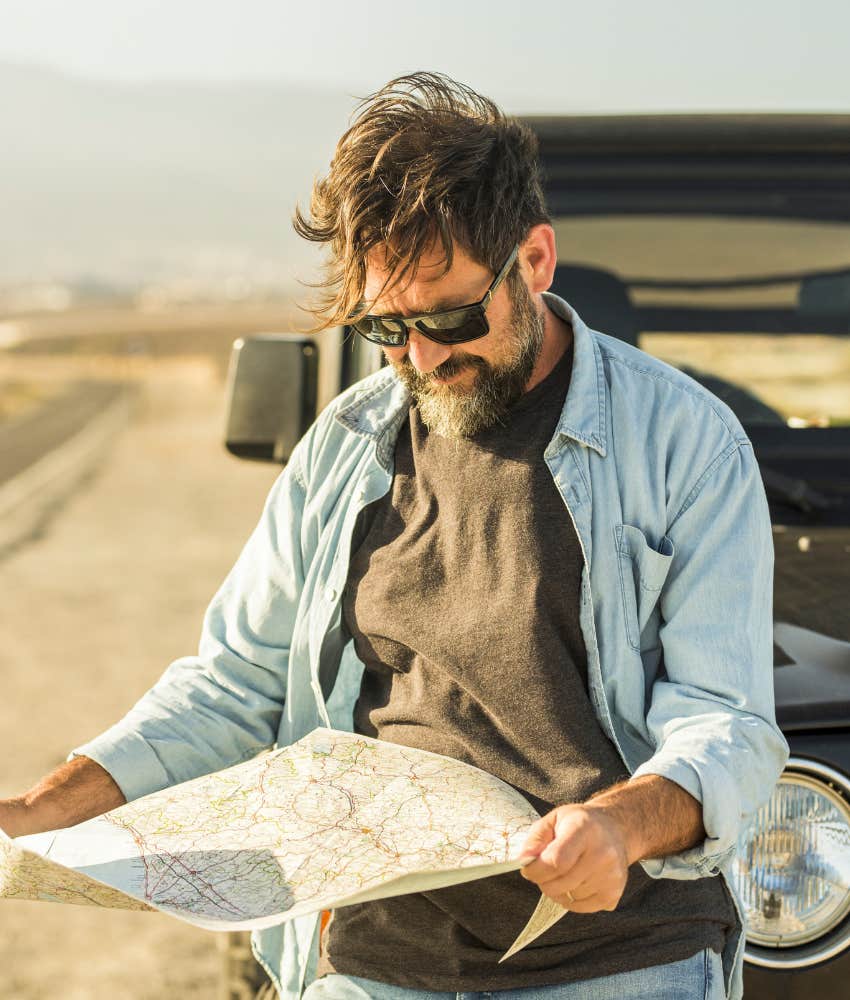 Adventurous person uses road map showing millennial navigation skill