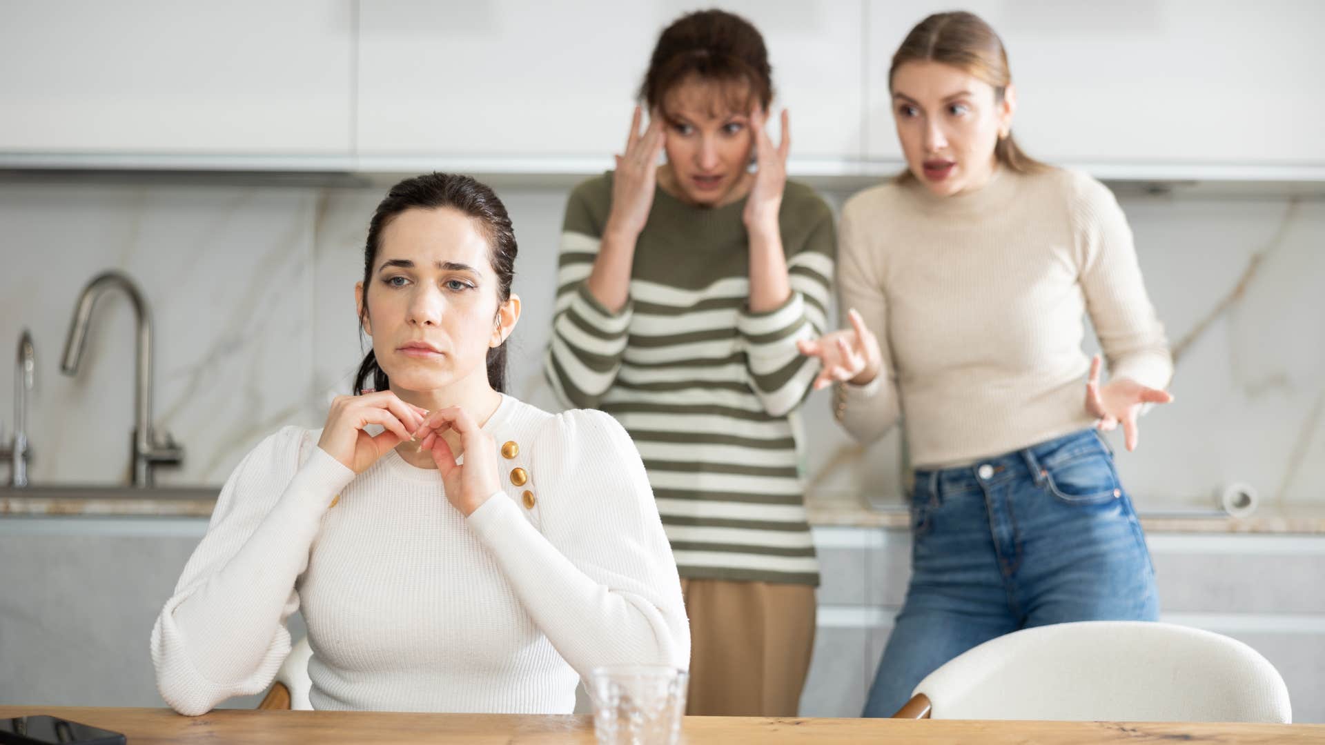 woman turned away from gossiping friends