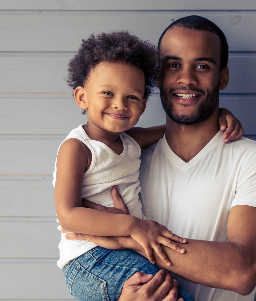 Dad holding little boy, raising him to feel safe and loved