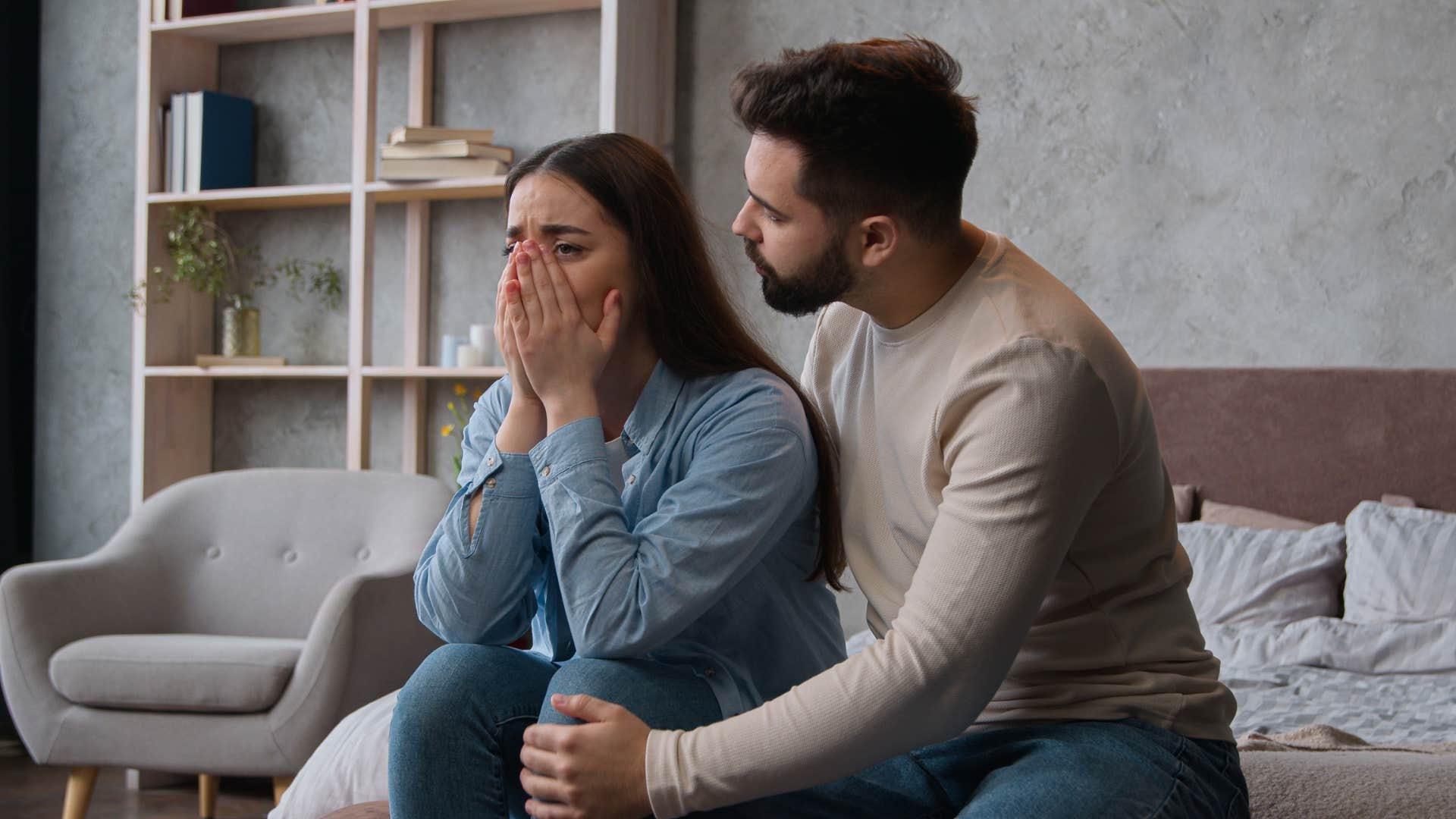 man comforting woman as he apologizes excessively 