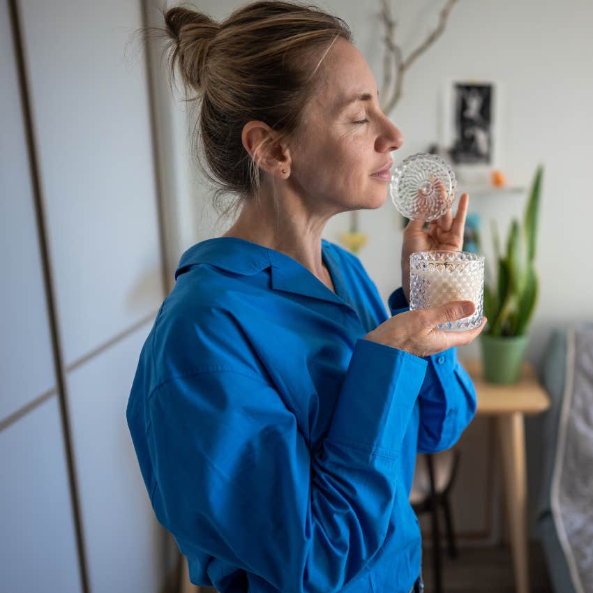 woman smelling candles that she'll never burn