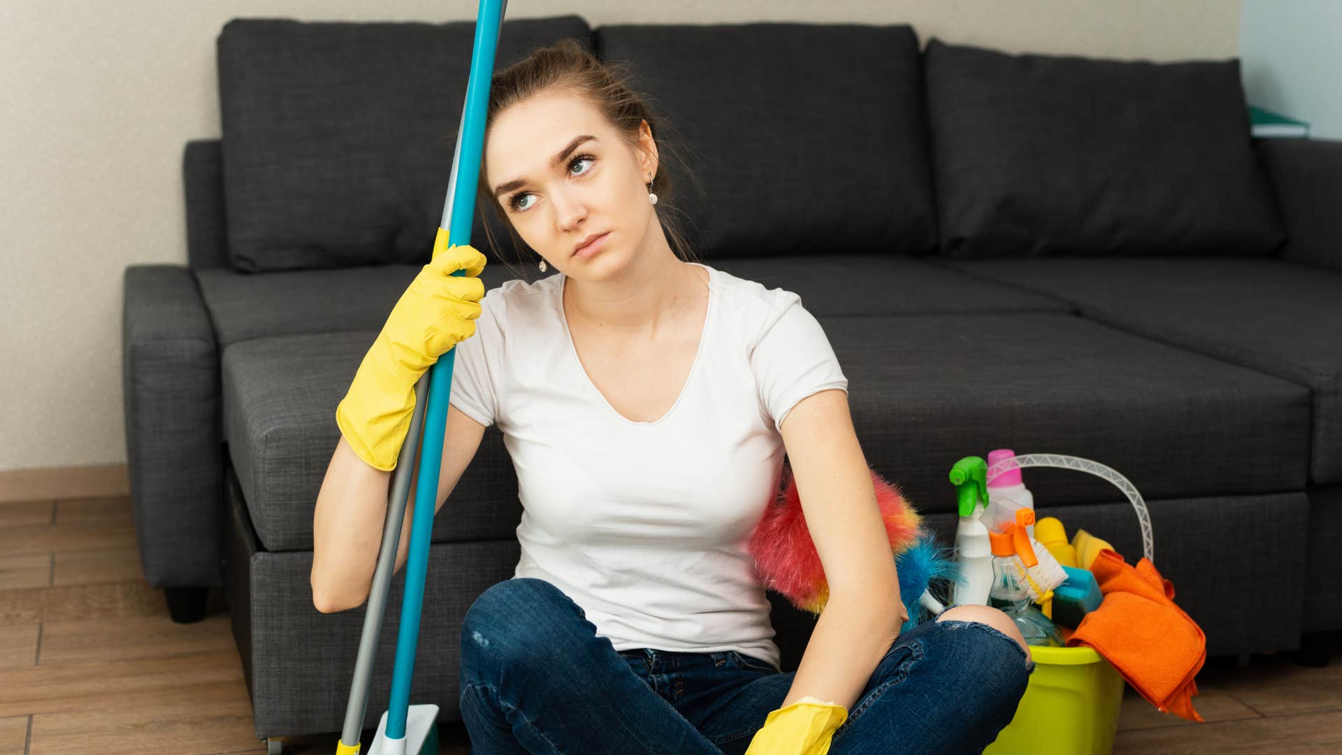 woman with mop looking annoyed after telling husband i fixed it