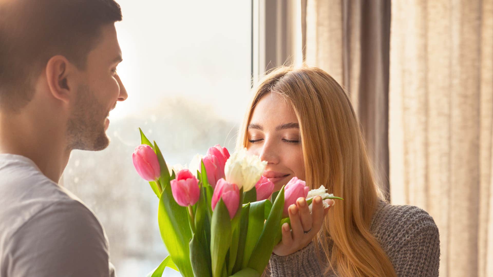 woman smelling flowers telling husband i didnt think youd remember